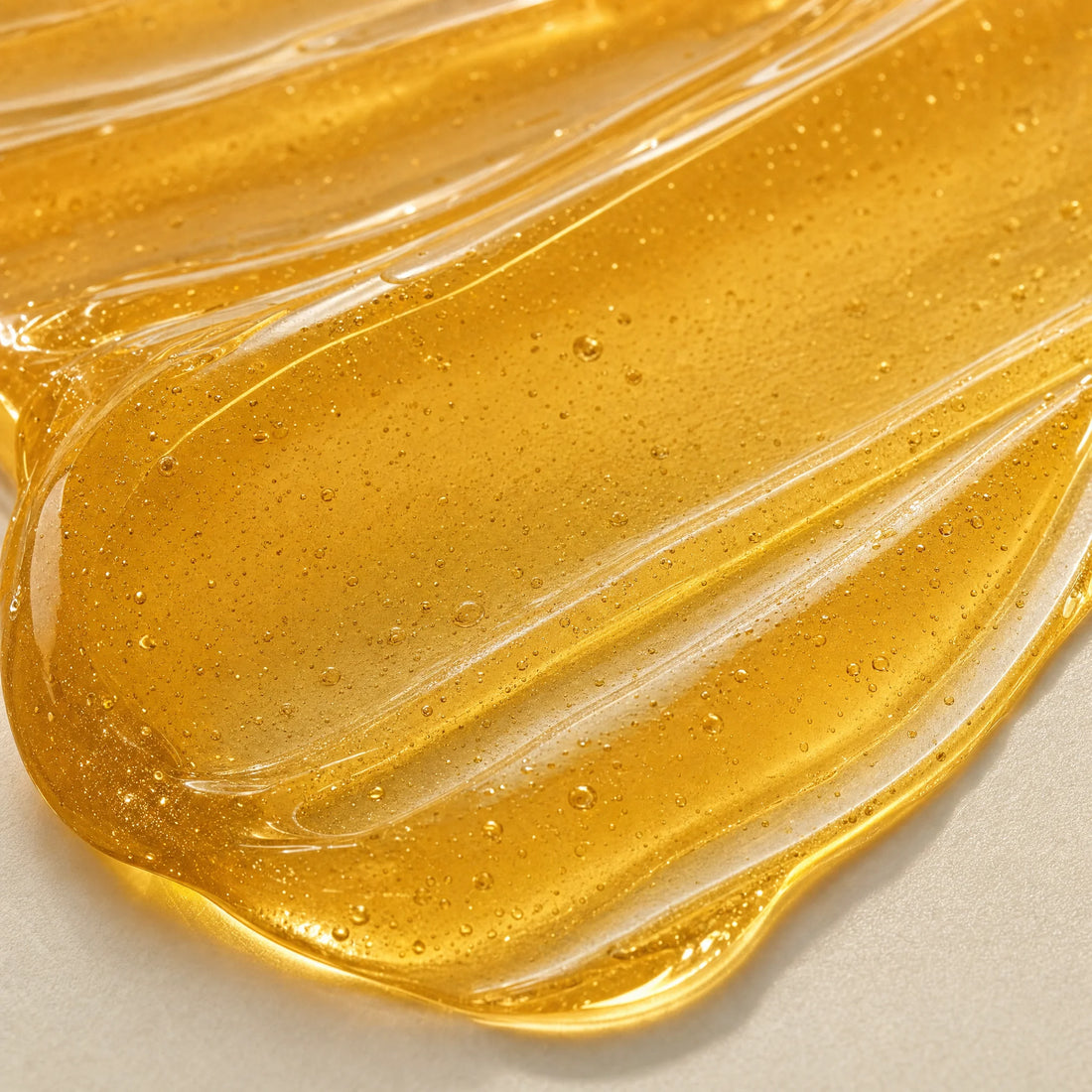 Close-up of the thick golden turmeric mask texture with a swatch drawn through it